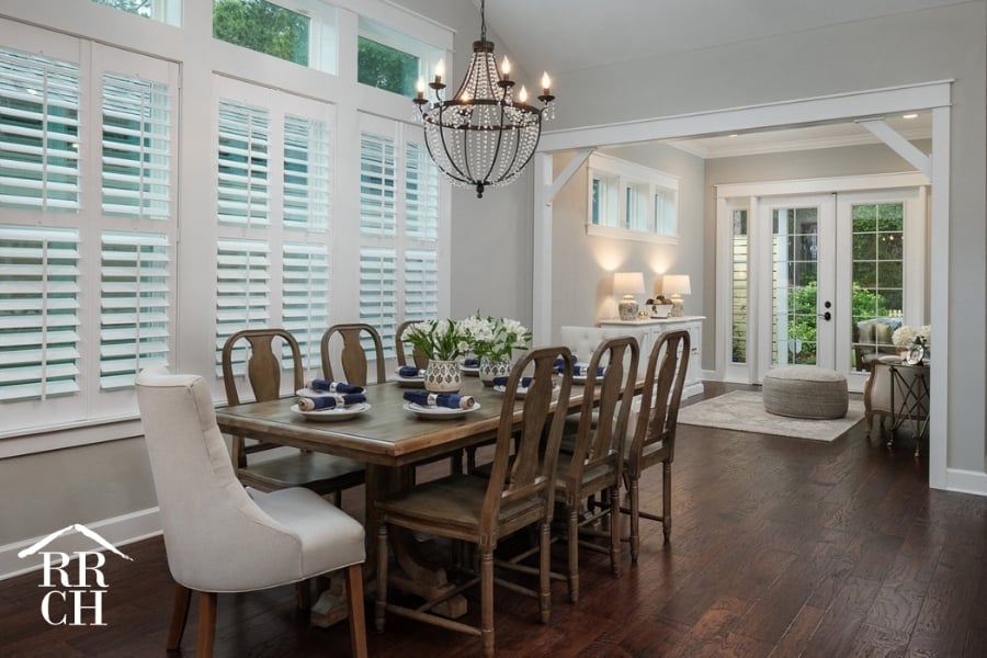 Custom Home Build Longleaf Dining Area with Large Dining Room Table and Accent Lighting Looking into Sitting Area with French Doors to Outdoor Living Area | Robinson Renovation & Custom Homes, Inc.