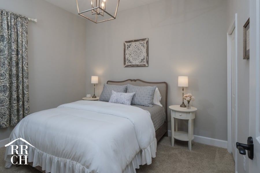 Custom Home Build Longleaf Guest Bedroom with Modern Farmhouse Lighting and Upholstered Headboard | Robinson Renovation & Custom Homes, Inc.