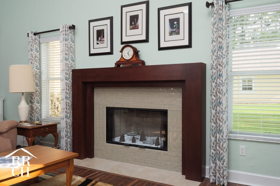 Living Room Fireplace with Sophisticated Glass Tile Surround and Dark Wood Mantel Against Beautiful Light Mint Walls  | Robinson Renovations and Custom Homes