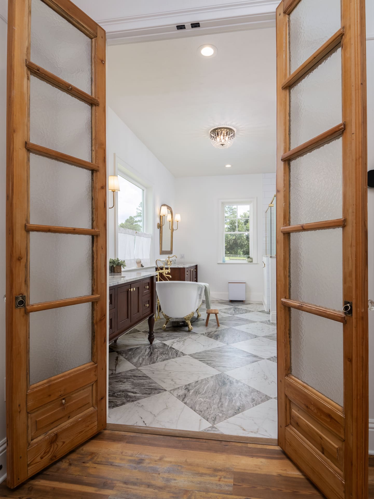 Gorgeous Doors into Primary Bathroom with Clawfoot Bathtub and Marble Floors Gorgeous Doors into Primary Bathroom with Clawfoot Bathtub and Marble Floors