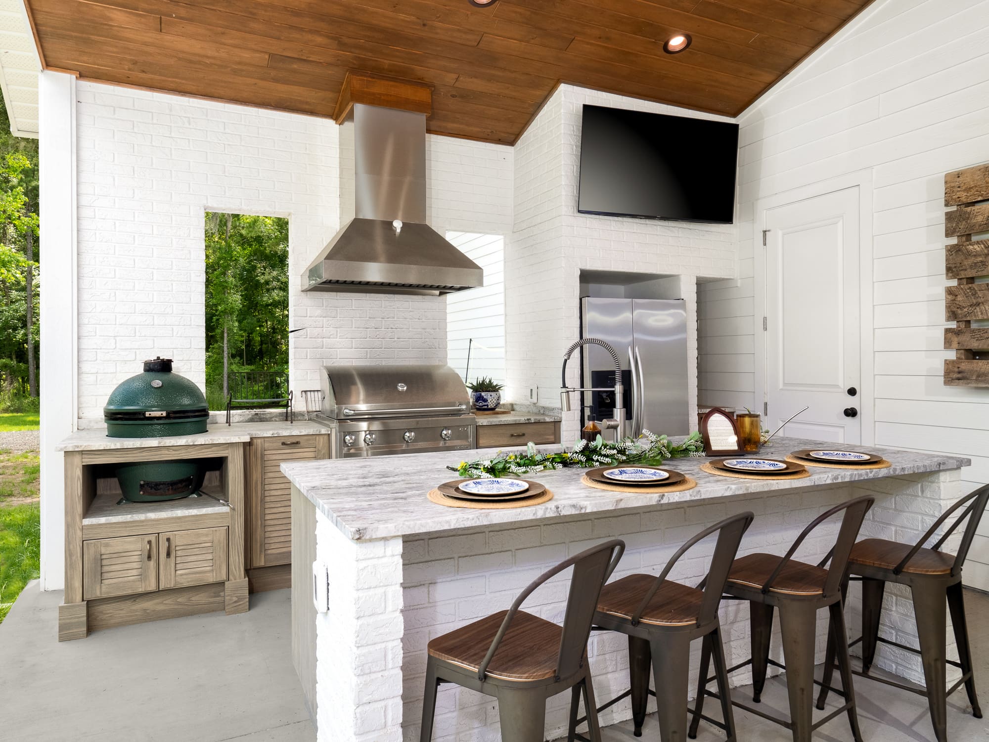 Gainesville-Outdoor-Living-Contractor-Robinson Renovation and Custom Homes-Outdoor Summer Kitchen with Bar Seating and TV in Gainesville Gainesville-Outdoor-Living-Contractor-Robinson Renovation and Custom Homes-Outdoor Summer Kitchen with Bar Seating and TV in Gainesville