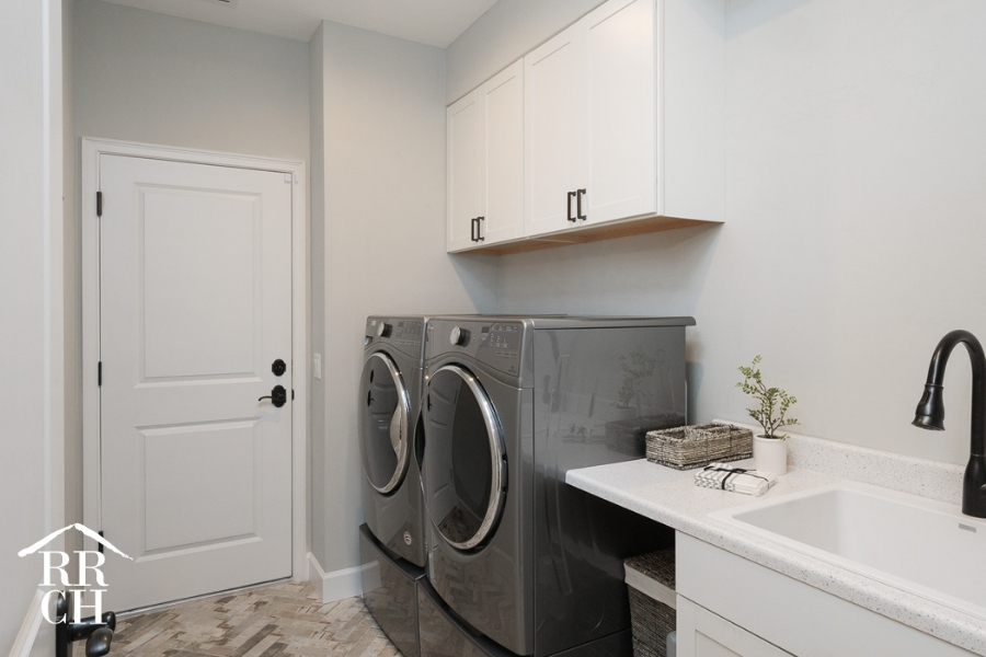 Custom Home Build Longleaf Laundry Room with Private Sink and Side by Side Washer and Dryer | Robinson Renovation & Custom Homes, Inc.