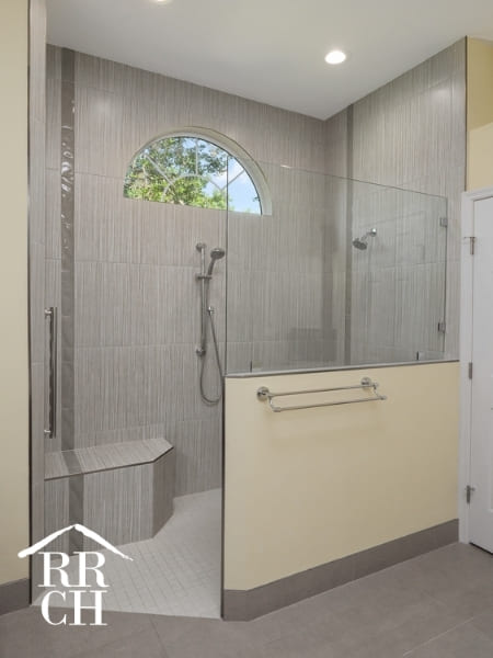 Walk-In Glass Shower with Seat and Two Sprayers with Natural Light and Stone Tiles | Robinson Renovations and Custom Homes