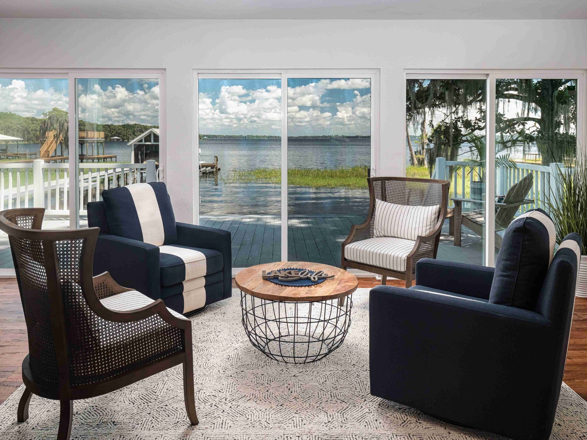 Living room in a custom home with floor-to-ceiling windows overlooking the water by Robinson Renovation & Custom Homes in Alachua County, FL